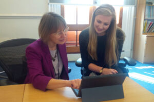 Lin Homer, Permanent Secretary HMRC, working on her laptop with her apprentice Olivia