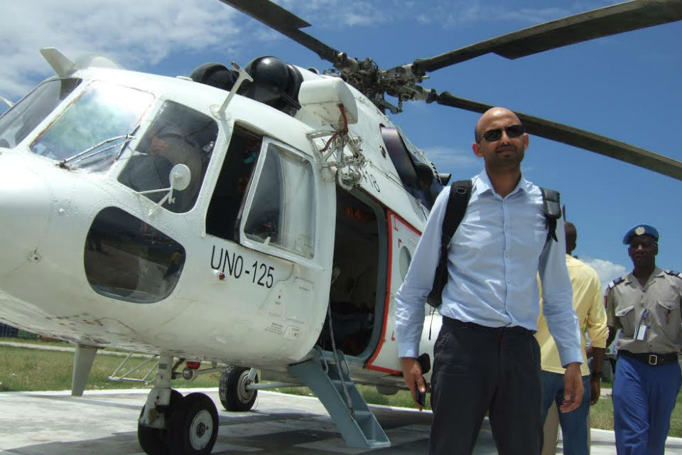 Mo Desai of DFID, with helicopter and overseas officials behind.