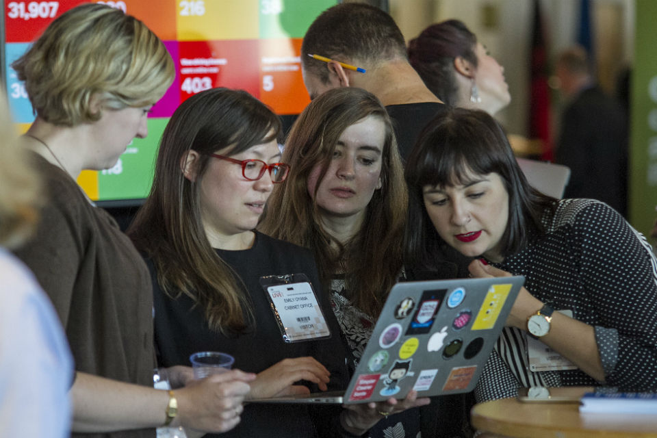 Delegates huddled around a laptop at the GDS stand Civil Service Live: Edinburgh