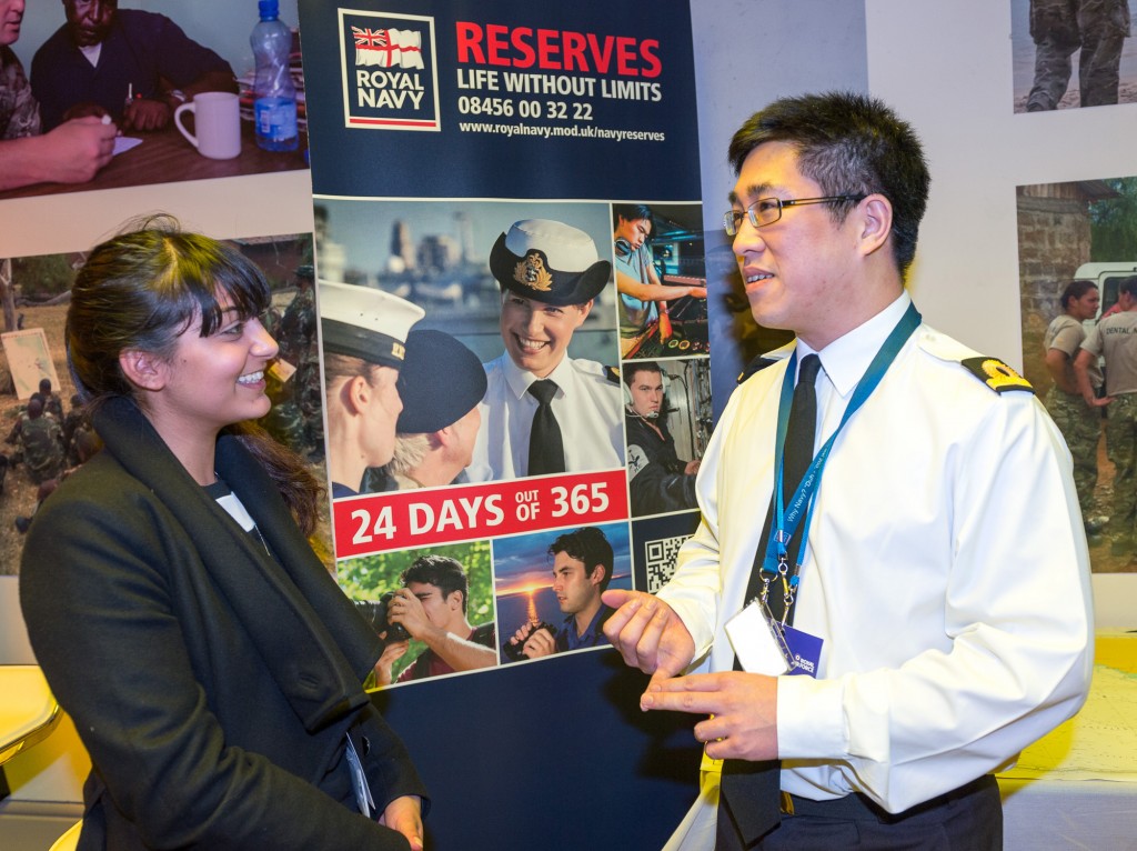Royal Naval Reservist (right) explaining Reserve Forces to a female visitor at the Reserves Experience