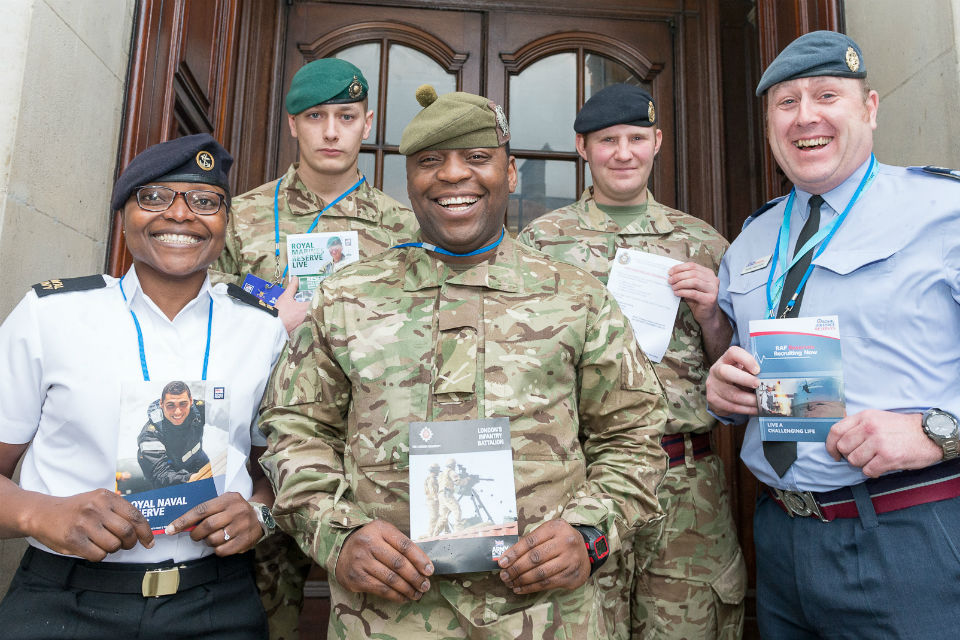 Five members of the Armed Forces Reserves on steps in front of glass-panelled door.