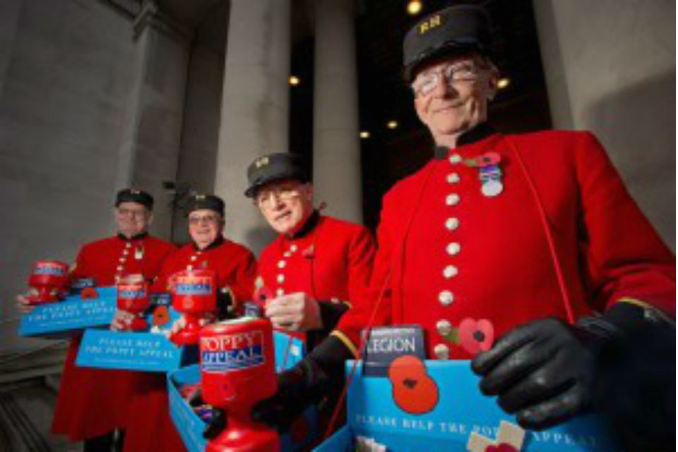 Four Chelsea pensioners in full uniform with British Legion poppy trays and collection boxes.