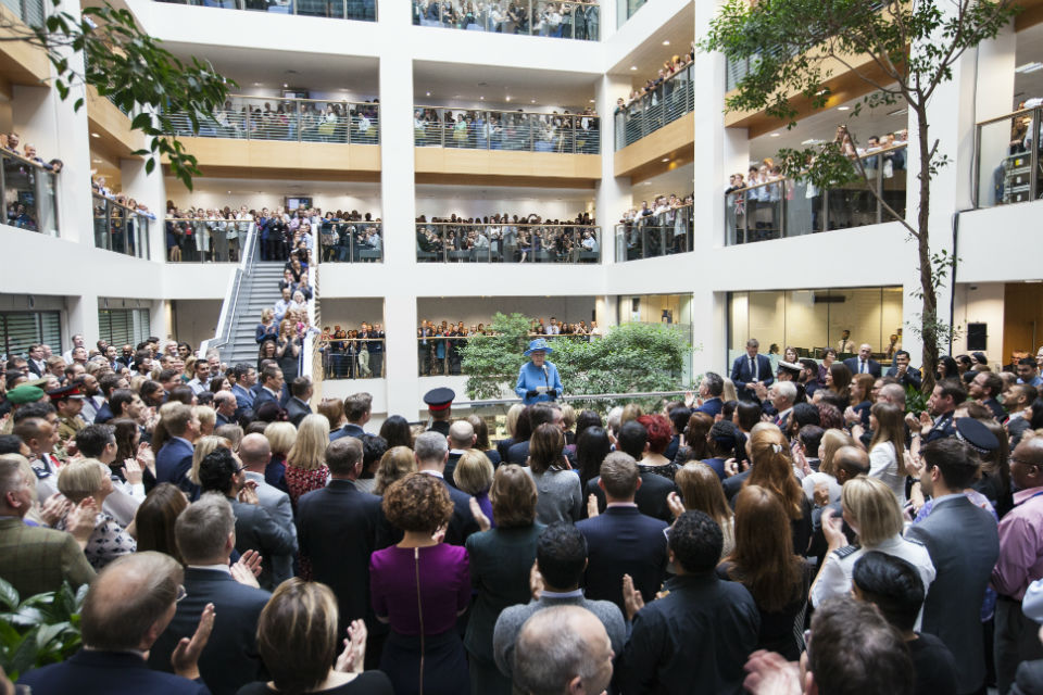 The Queen, in blue, centre, addressing large audience of civil servants in atrium at Home Office building.