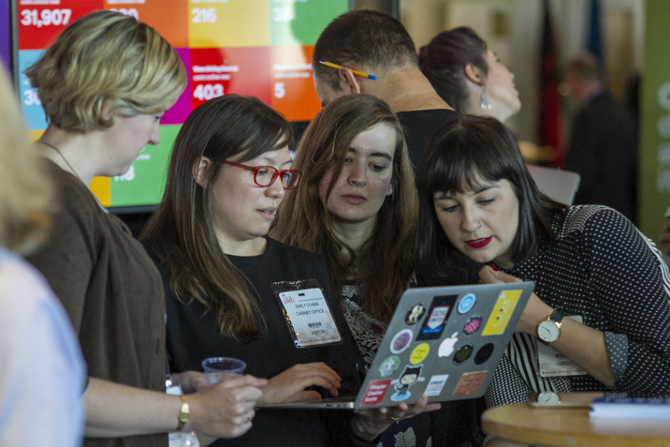 Staff working collaboratively around a laptop at Civil Service Live 2015: Edinburgh