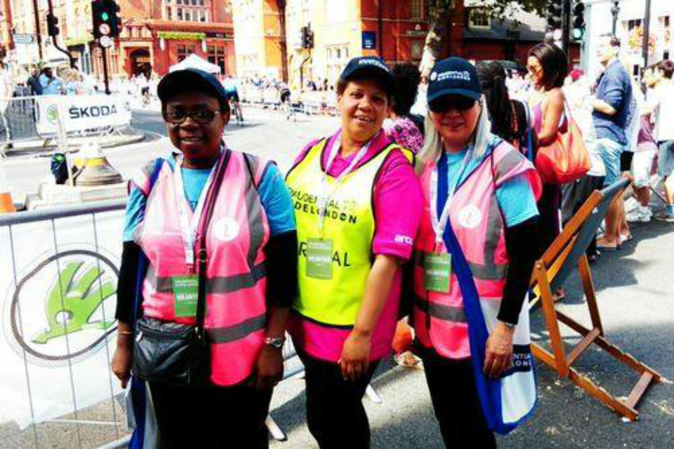 Three women in high vis jackets and hats