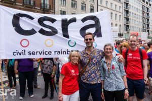 People pose in front of CSRA banner