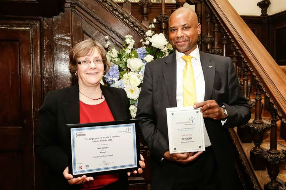Man and woman holding awards