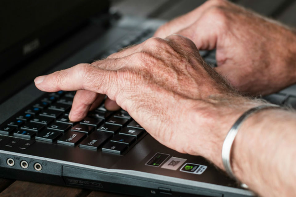 Image of two hands on a computer keyboard