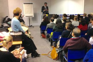 Man addressing seated audience