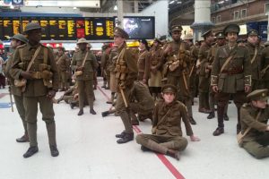 Men in WWI uniforms at a station