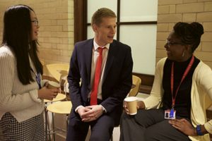 Man in suit and tie between two women