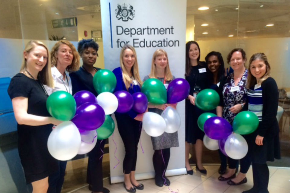 Women in line with multi-coloured balloons