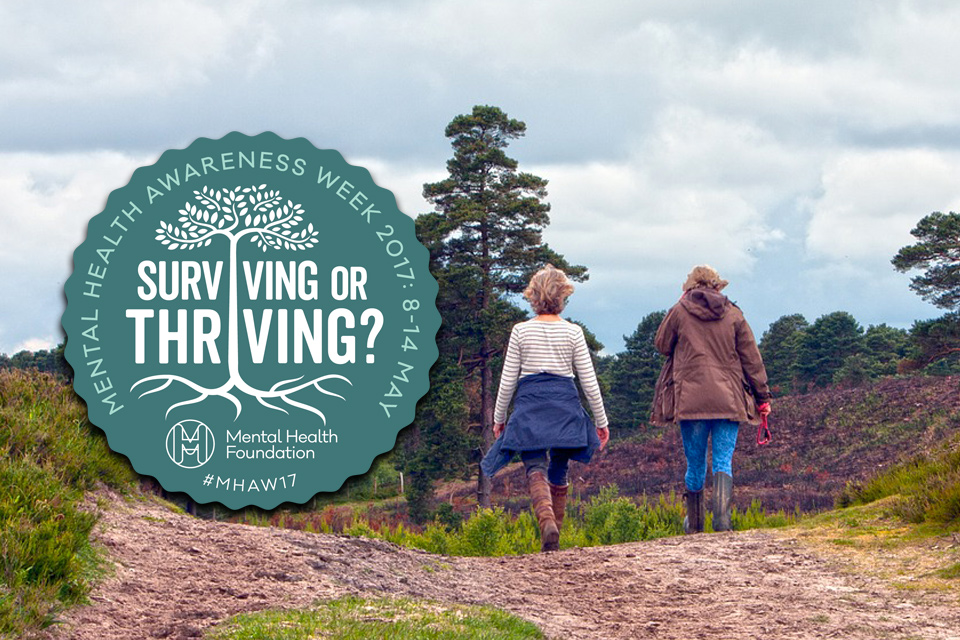 Two people walking in countryside with Mental Health Awareness Week 2017 badge superimposed.