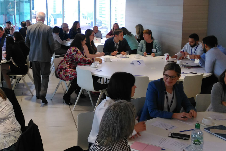 Men and women in discussion at round tables