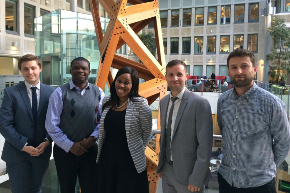 Group of four men and a woman in office building