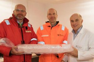 Three men holding ice core sample