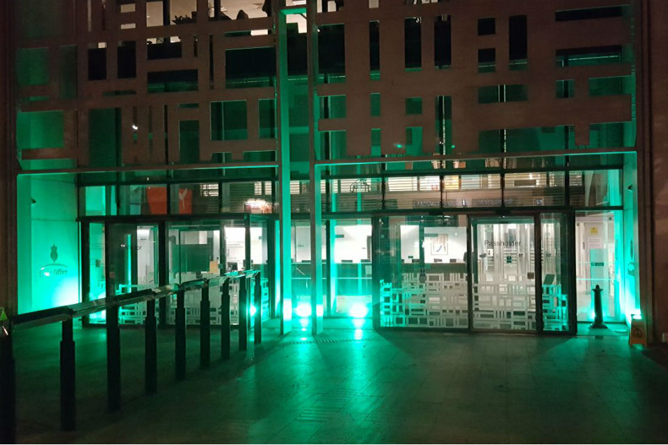 Exterior of building bathed in green light