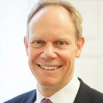 Head and shoulders of man in suit and tie