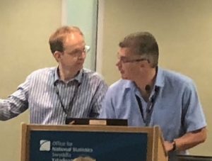 Two men at lectern during conference