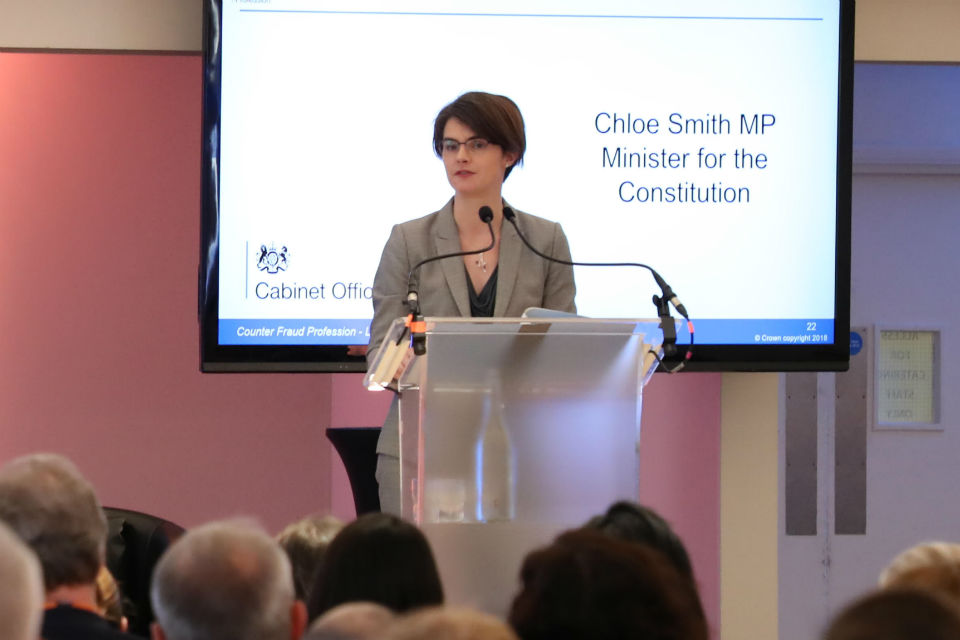 Chloe Smith speaking from a lectern at an event