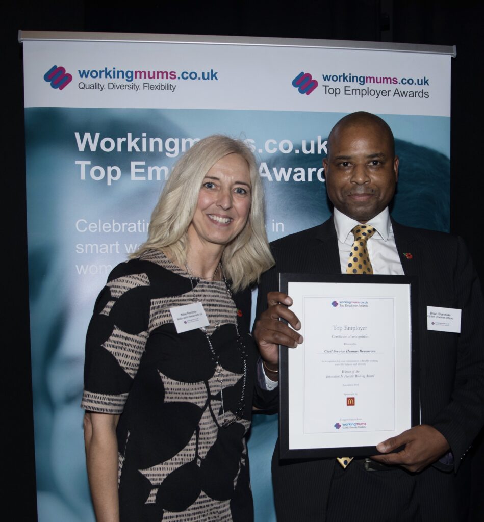 Man holding up framed award certificate next to female presenter