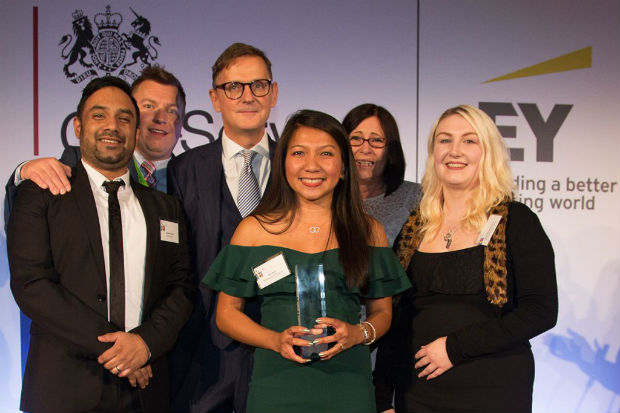 Members of Team Chaffinch with presenter Jonathan Jones on the stage at the 2018 Civil Service Awards, one of them holding the award.