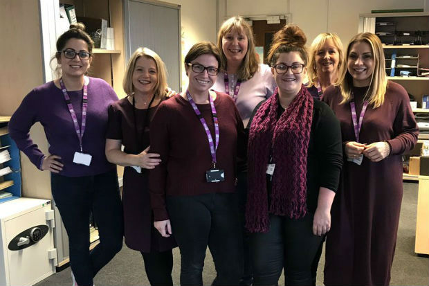 A group of women dressed in various shades of purple