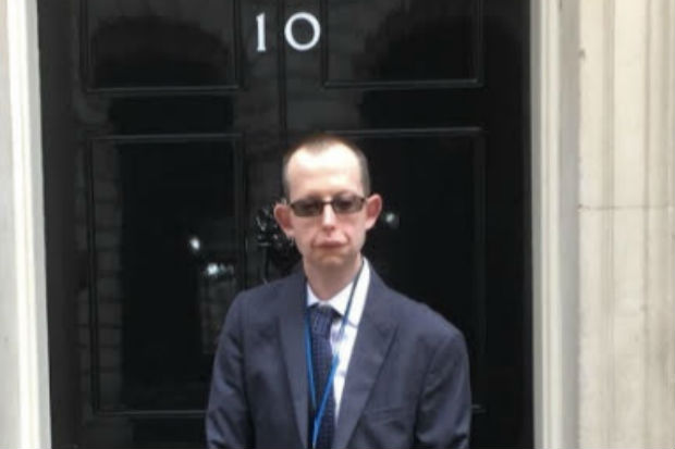 Photograph of Andrew Wight standing outside the door of No. 10 Downing Street