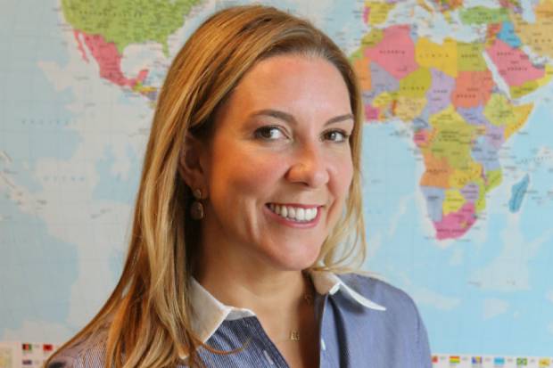 Antonia Romeo, Permanent Secretary, Department for International Trade, and Civil Service Gender Champion, standing in front of a wall-mounted map of the world