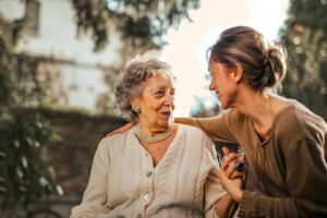 Young woman carer helping older woman