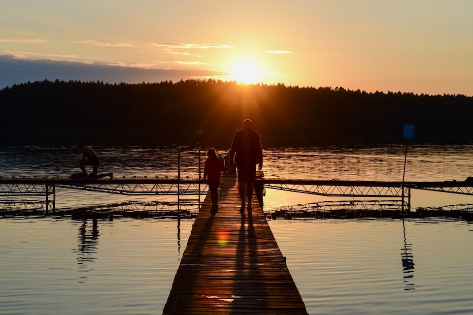 Image of a father and daughter walking at sunset