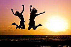 Image showing two women in silhouette jumping