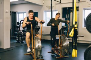 Man and woman exercising on bikes in a gym