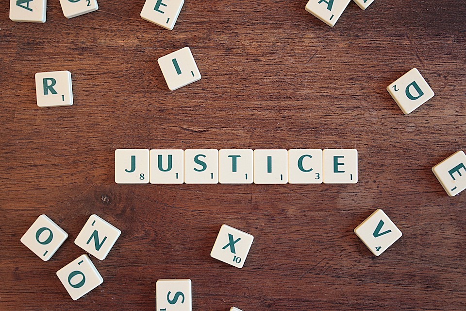 Image of the letters spelling Justice on a scrabble board