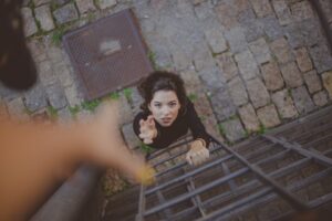 Image of a young woman climbing a ladder to depict social mobility