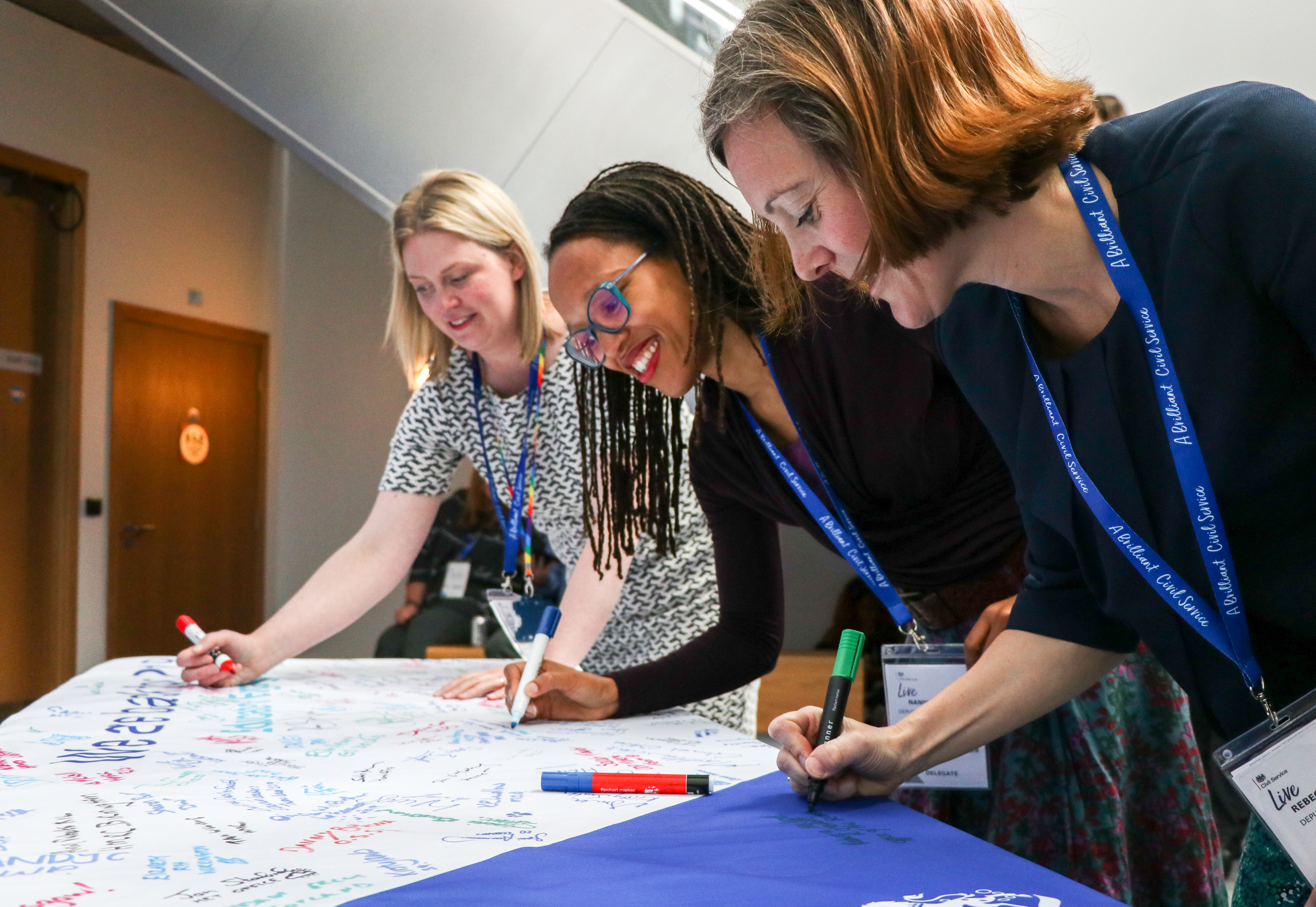 CS Live attendees writing on a banner