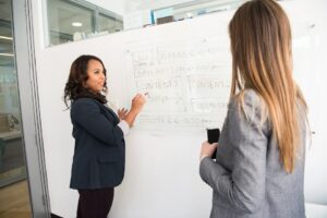 Image showing two female teachers writing on a whiteboard