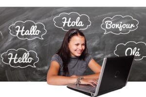Woman on laptop with speechbubbles saying hello in variety of languages
