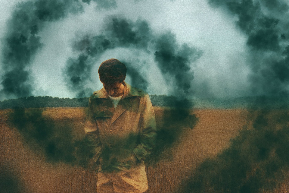 Image of a man walking, head down surrounded by mist