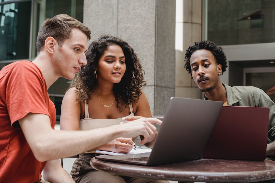 Colleagues discussing work at a laptop in an office environment