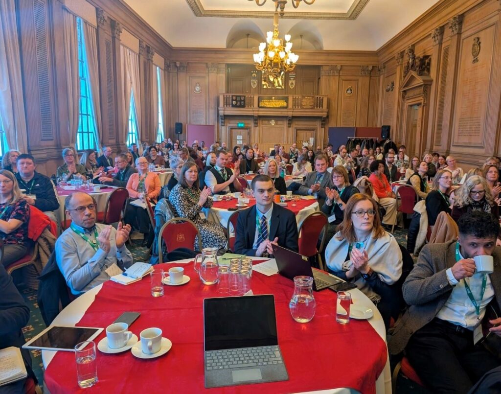 Civil Servants from the Leeds Good Work, Health and Skills Summit sat around tables clapping